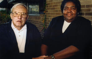 C.P. Ellis, a white man, and Ann Atwater, a Black woman, sit together holding hands.