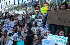 Image of young people holding protest signs as part of a protest for action on climate change