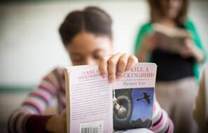 Picture of student holding up a book.