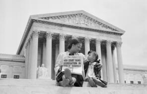 ca. May 1954, Washington, DC, USA --- Nettie Hunt and her daughter Nickie sit on the steps of the U.S. Supreme Court. Nettie explains to her daughter the meaning of the high court's ruling in the Brown Vs. Board of Education case that segregation in public schools is unconstitutional