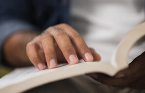 Close Up of Male Hand on Open Book And Reading