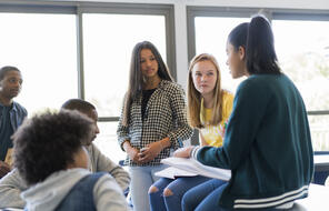 Multi-ethnic students discuss in classroom