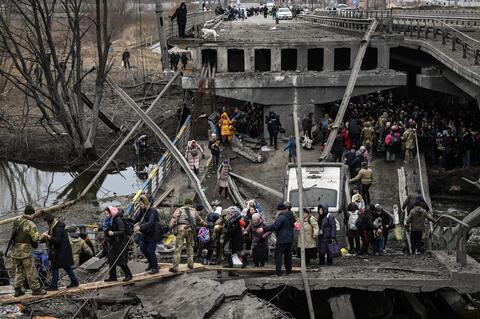 People cross a destroyed bridge as they evacuate the city of Irpin, northwest of Kyiv, during heavy shelling and bombing on March 5, 2022, 10 days after Russia launched a military in vasion on Ukraine. (Photo by Aris Messinis / AFP) (Photo by ARIS MESSINIS/AFP via Getty Images)