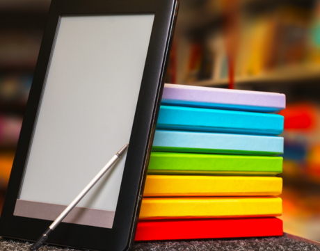 Stock photo of rainbow notebooks and tablet.