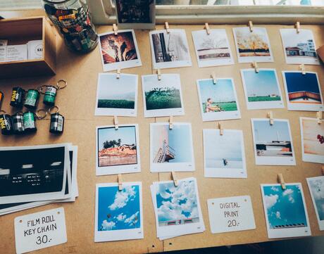 Assorted images of the outdoors organized in a grid on a beige wooden table.