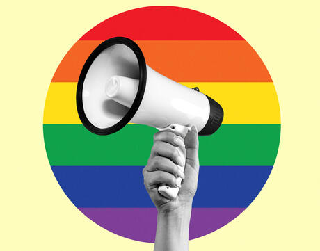 Female hand with megaphone isolated on LGBT flag background.