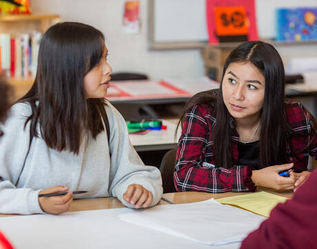 Female students engage in classroom discussion.