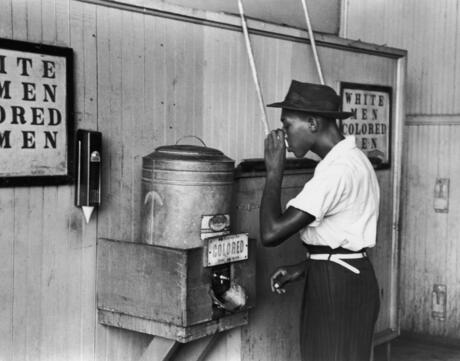July 1939: An African-American man drinking at a segregated drinking fountain in Oklahoma City, Oklahoma.