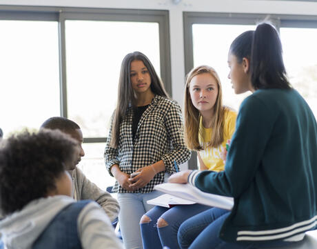 Multi-ethnic students discuss in classroom